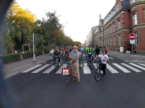 Photo prise sur l'avenue de la république au niveau de la poste où l'on voit une foule à vélo à l'arret qui fait coucou au photographe